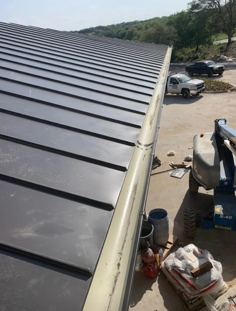 Standing seam panel and gutter detail on a metal roofing jobsite in Antis